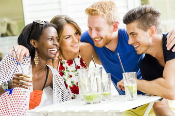 Happy young people laughing a being happy at a table