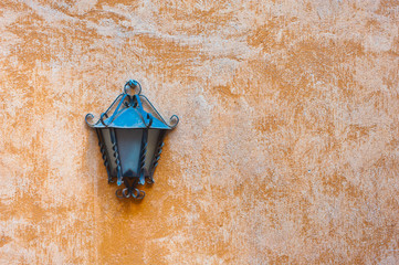 Outdoor garden lamp on orange wall