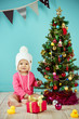 Newborn hanging a decorative item on christmas tree