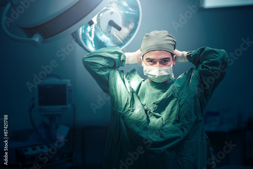 Fotografía Male surgeon tying mask at operating room