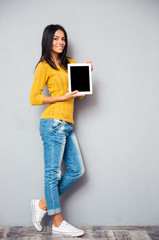 Wall Mural - Smiling woman showing tablet computer screen