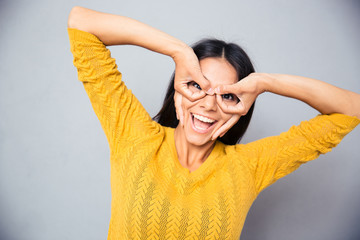 Wall Mural - Woman looking at camera through fingers