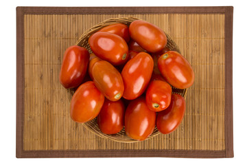 Some tomatoes over a wooden surface on a tomato field as backgro