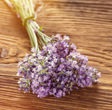 Fototapeta Lawenda - Wellness treatments with lavender flowers on wooden table. Spa still-life.