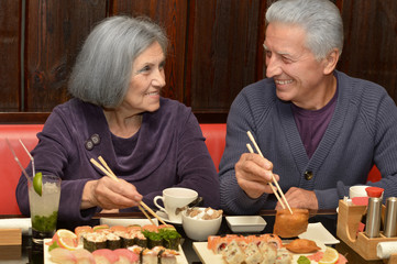 Elderly couple eating sushi