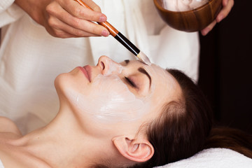 spa treatment. beautiful woman with facial mask at beauty salon.