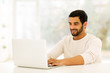 © michaeljung - young indian man using laptop