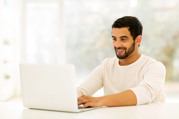 young indian man using laptop