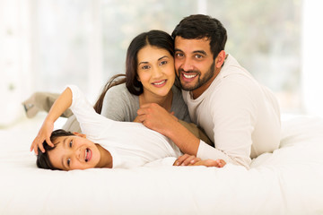 Wall Mural - little indian boy lying on bed with his parents