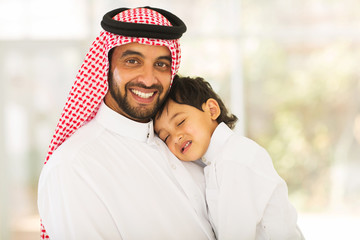 Wall Mural - Arabian father holding his sleeping baby