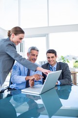 Business people looking at laptop computer 