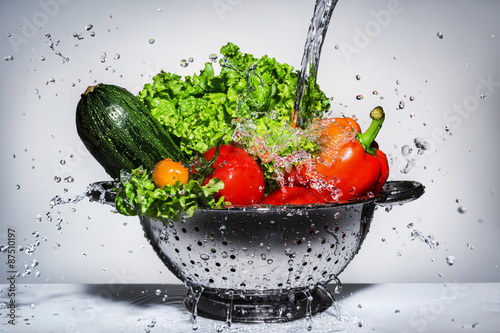 Fototapeta na wymiar vegetables in a colander under running water