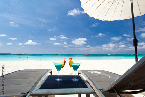 Blue Curacao cocktail avec tranche d'ananas sur la plage blanche Tableau sur Toile