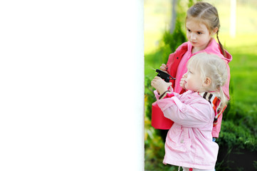 Wall Mural - Two little girls helping in a garden