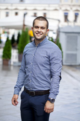 Wall Mural - Young handsome man in in plaid shirt on the background of summer