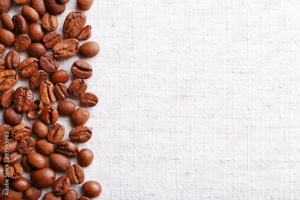 Frame of coffee beans on color sackcloth background