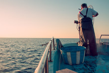 Fishing On Boat In Sea. Sunset 