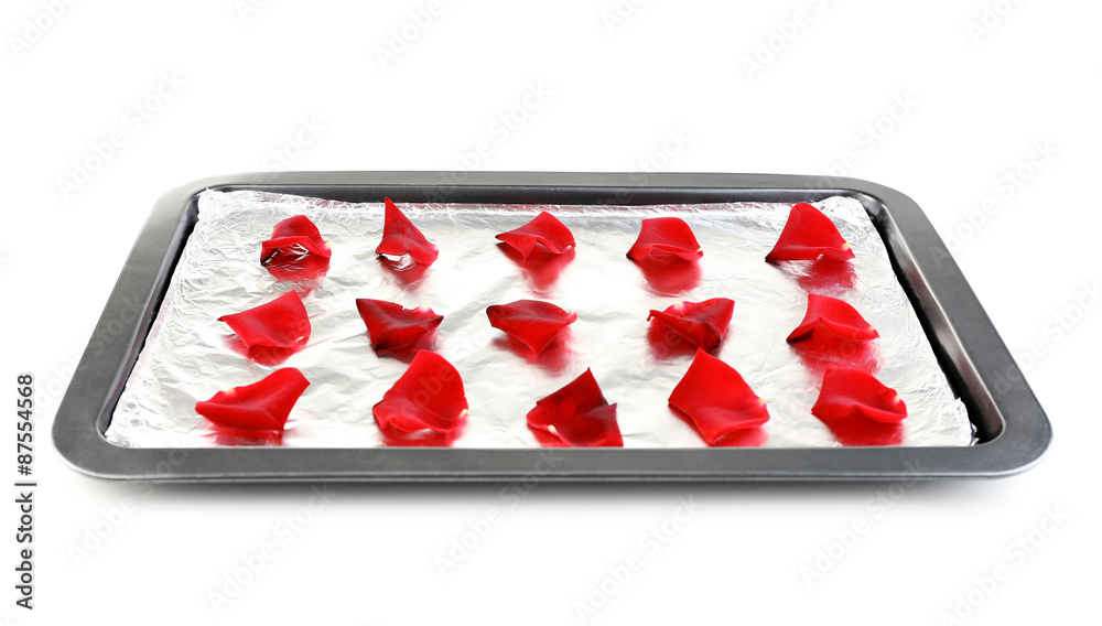 Roses petals on tray, isolated on white. Candied flowers concept