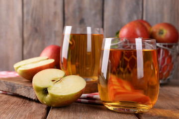 Wall Mural - Glasses of apple juice on wooden background