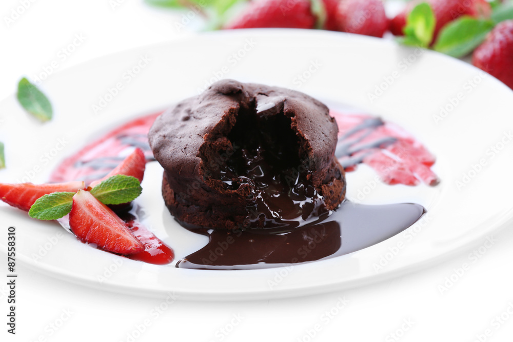 Chocolate fondant with strawberries on white plate, closeup