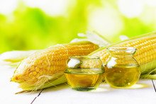 Corn Oil And Corn Cobs On A Garden Table