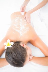 Wall Mural - Beautiful brunette enjoying a salt scrub treatment