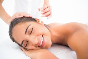 Wall Mural - Beautiful woman receiving ear candle treatment at spa center