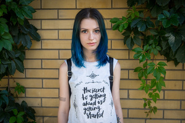 Wall Mural - Blue haired girl posing on the background of ivy