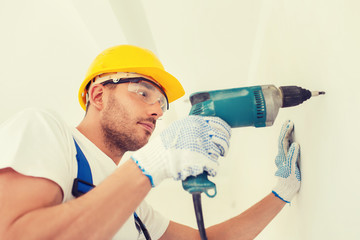 Canvas Print - builder in hardhat working with drill indoors