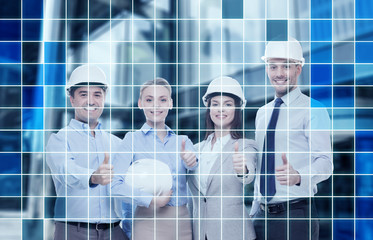 Canvas Print - happy business team in office showing thumbs up