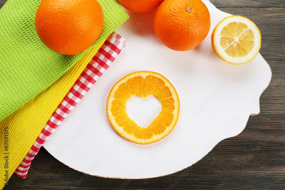 Orange slice with cut in shape of heart on table close up