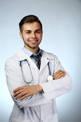 Poster - Male doctor with stethoscope on blue background