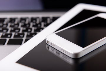 Wall Mural - Tablet and mobile phone on keyboard, closeup