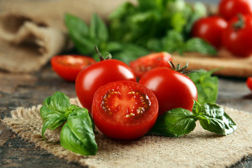 Wall Mural - Cherry tomatoes with basil on wooden table close up