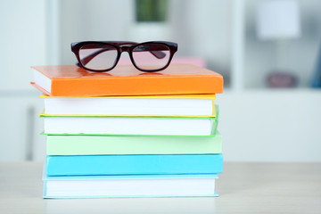 Sticker - Stack of books with glasses on wooden table in room