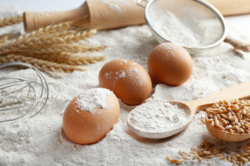 Poster - Wheat and eggs on white flour background