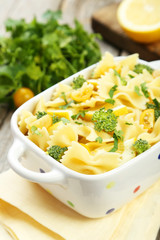 Delicious pasta with with broccoli in bowl on grey wooden backgr