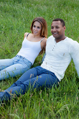 Canvas Print - Happy couple lying on the grass in the field