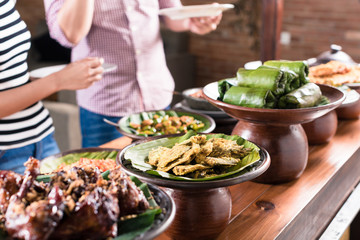 People choosing food at Indonesian buffet in restaurant