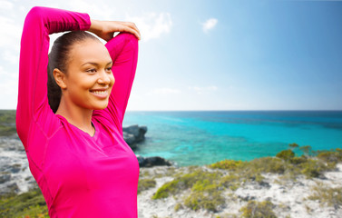 smiling african woman stretching hand on beach