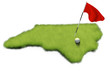 Golf ball and flag pole on course putting green shaped like the state of North Carolina