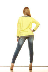 Wall Mural - woman in denim pants high yellow shirt back view