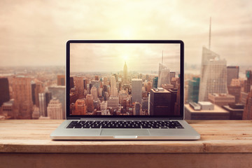 laptop computer over new york city skyline. retro filter effect