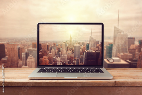 Fotografía Laptop computer over New York city skyline. Retro filter effect