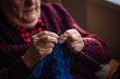 © D'Action Images - The old woman sits at home and knits garments