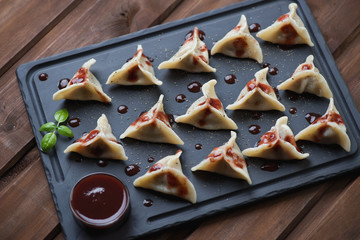 Sticker - Khinkali served with black pepper and tkemali sauce, studio shot