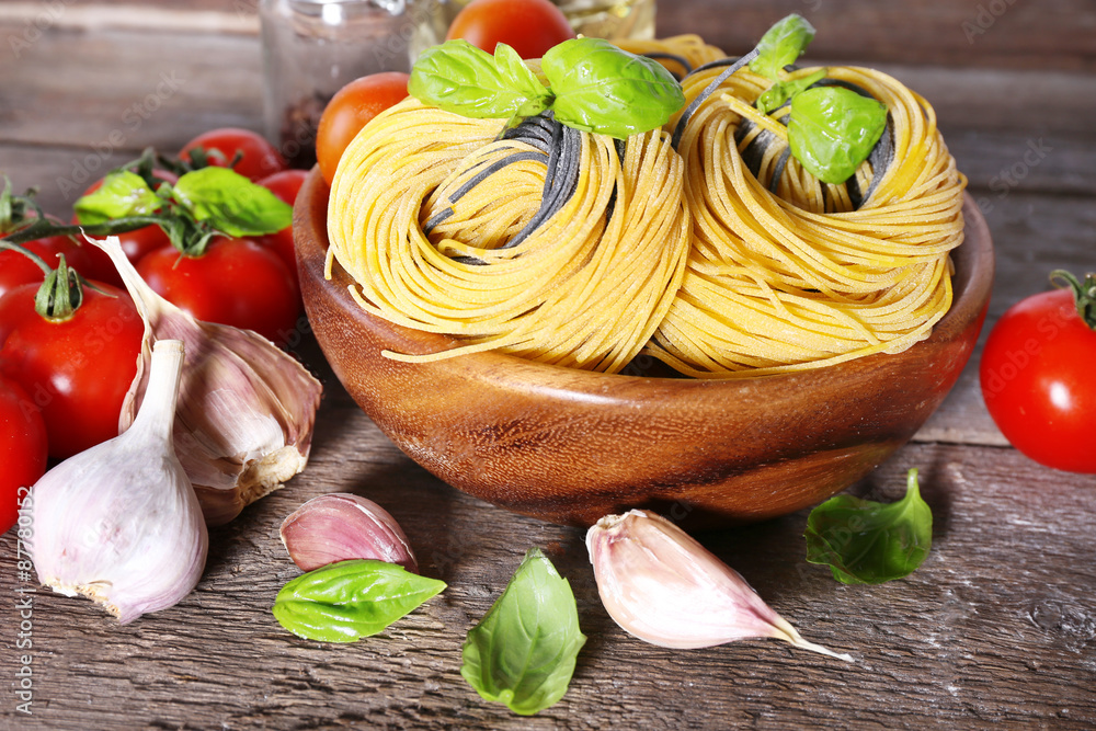 Pasta with cherry tomatoes and other ingredients on wooden table background