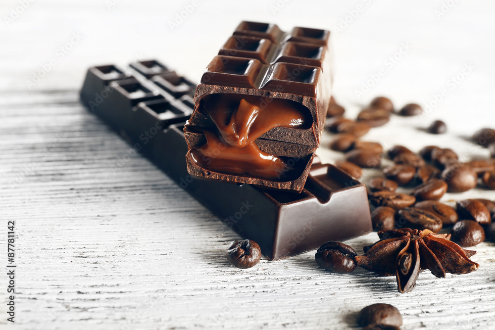 Stuffed chocolate with coffee beans on wooden table, closeup