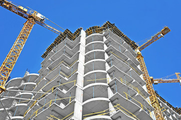  Crane and building construction site against blue sky