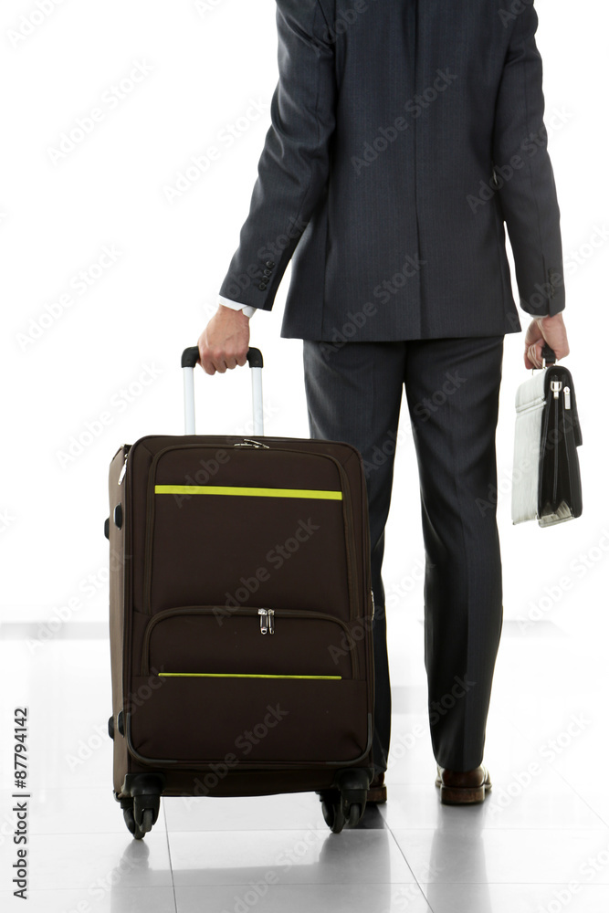 Man holding suitcase on light background